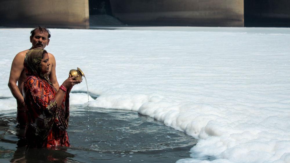 Cette femme poursuit le rite, sans un regard pour la mousse qui l'environne.